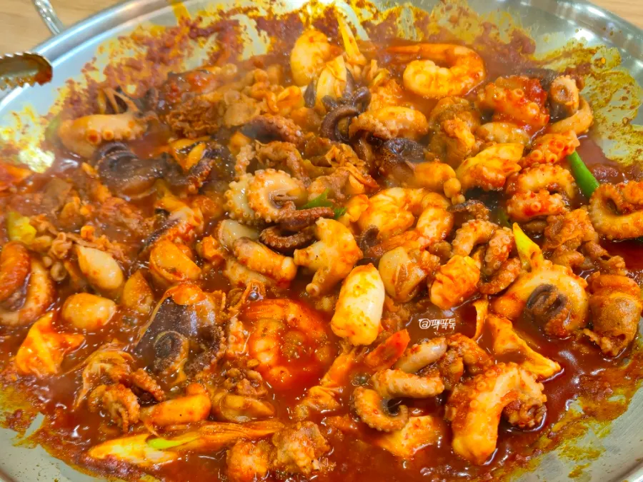 Close-up of jjukkumi mixed with beef belly on the hot plate