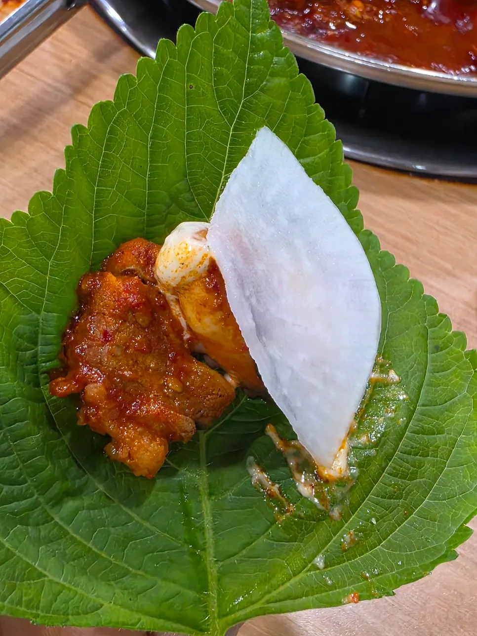 Jjukkumi dan saus bawang putih di atas daun selada