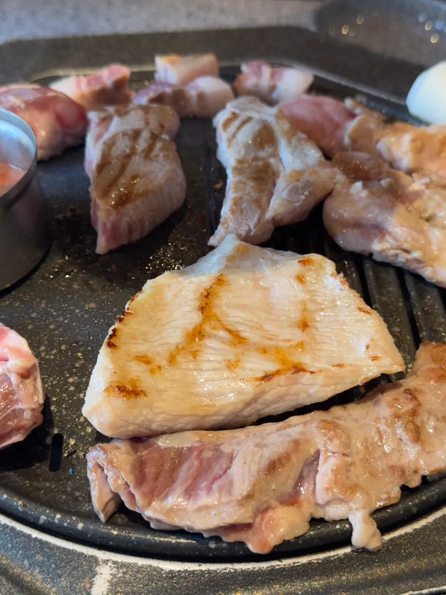 Staff grilling thick-cut pork