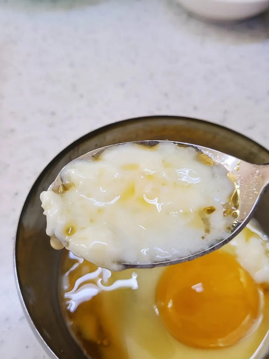Breaking the soft-boiled egg into the broth
