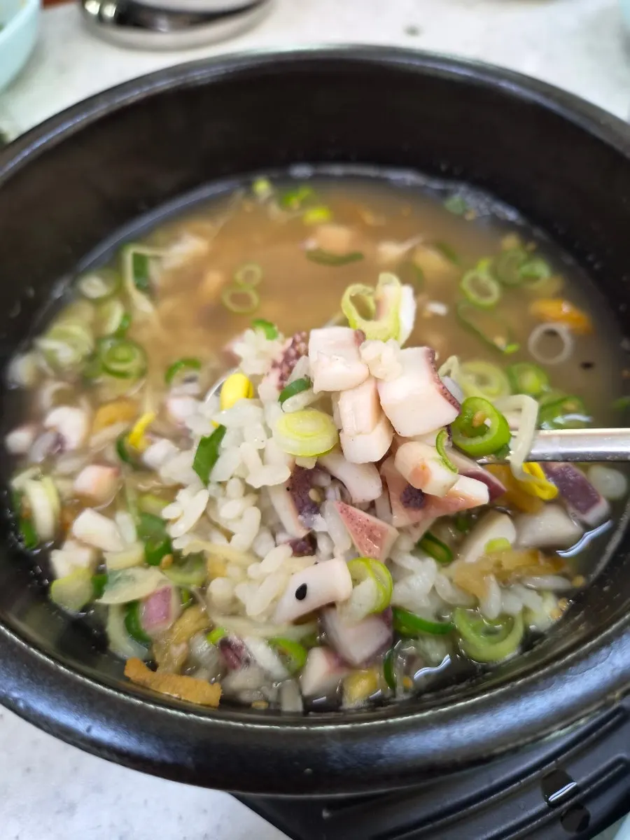 Spoonful of broth-soaked rice topped with salted shrimp