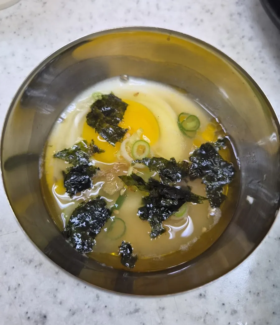 Poached egg topped with broth and gim