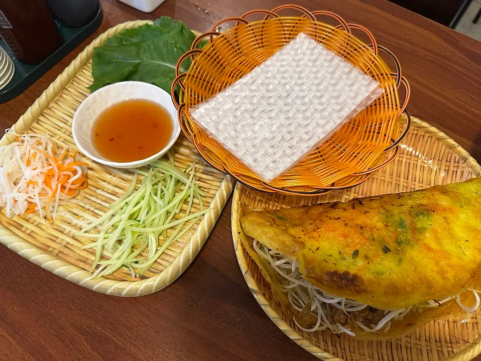 A full spread of banh xeo with rice paper and vegetables