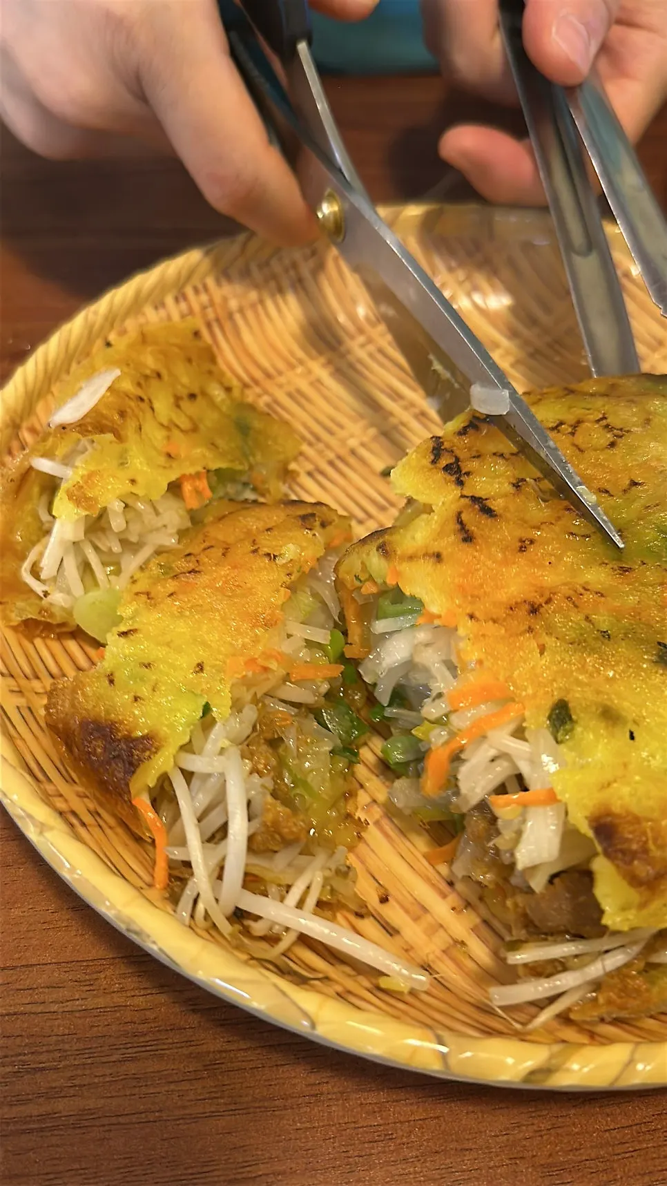 Cutting the banh xeo pancake into bite-sized pieces