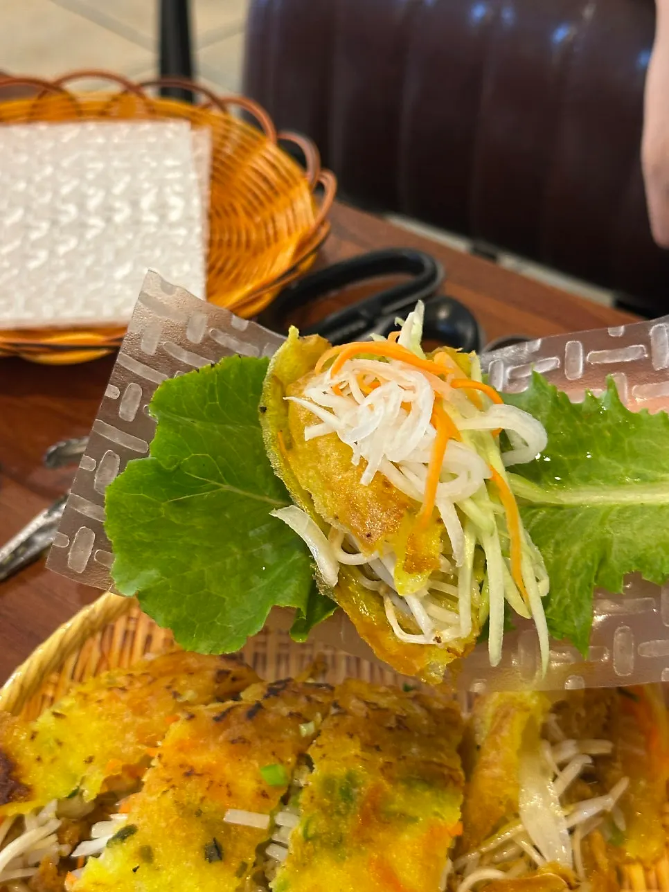 Lettuce and banh xeo placed on a sheet of rice paper