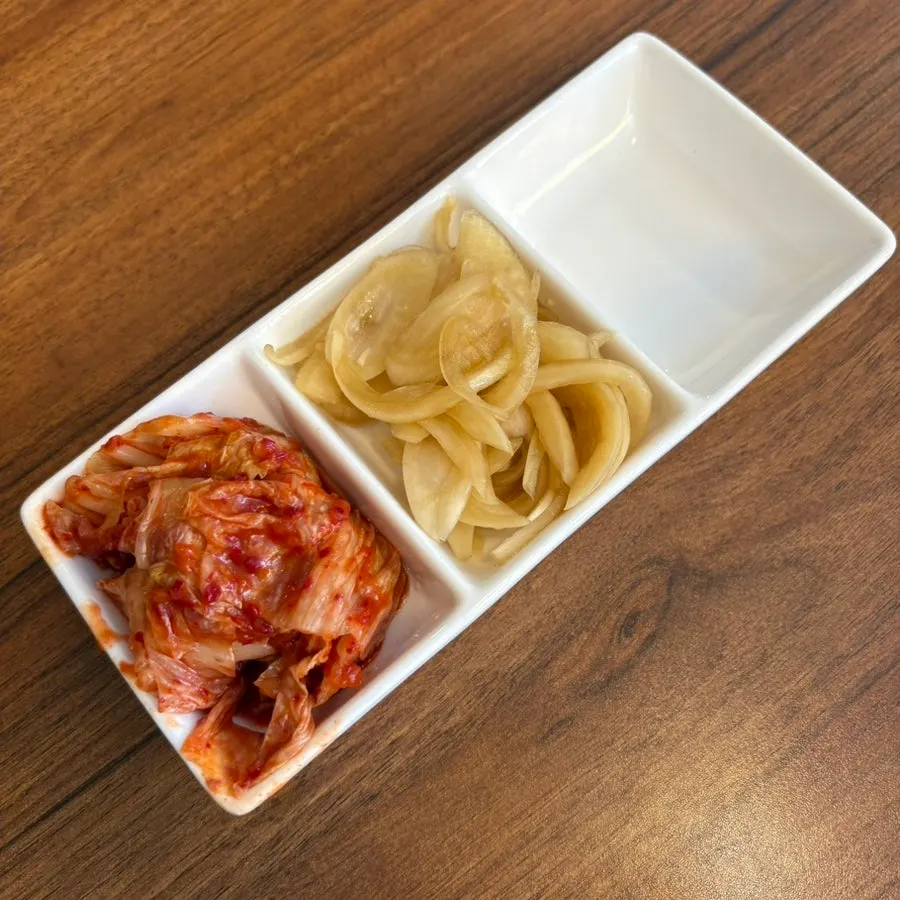 Pickled onions and kimchi served as side dishes