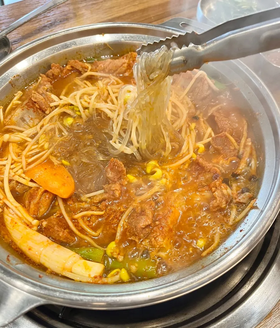 Glass noodles and bean sprouts in bubbling galbi hot pot