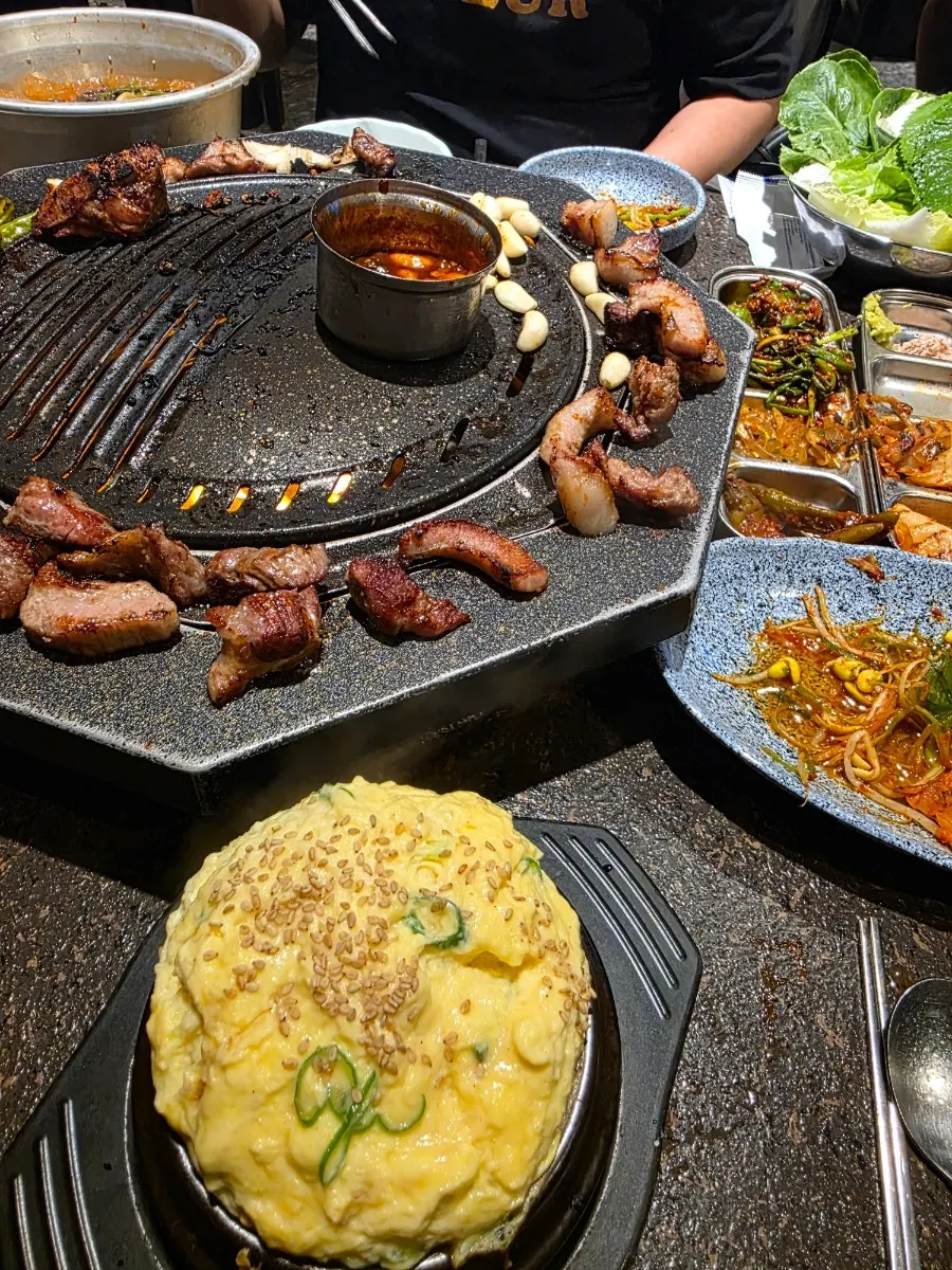Staff member grilling meat on the tabletop grill
