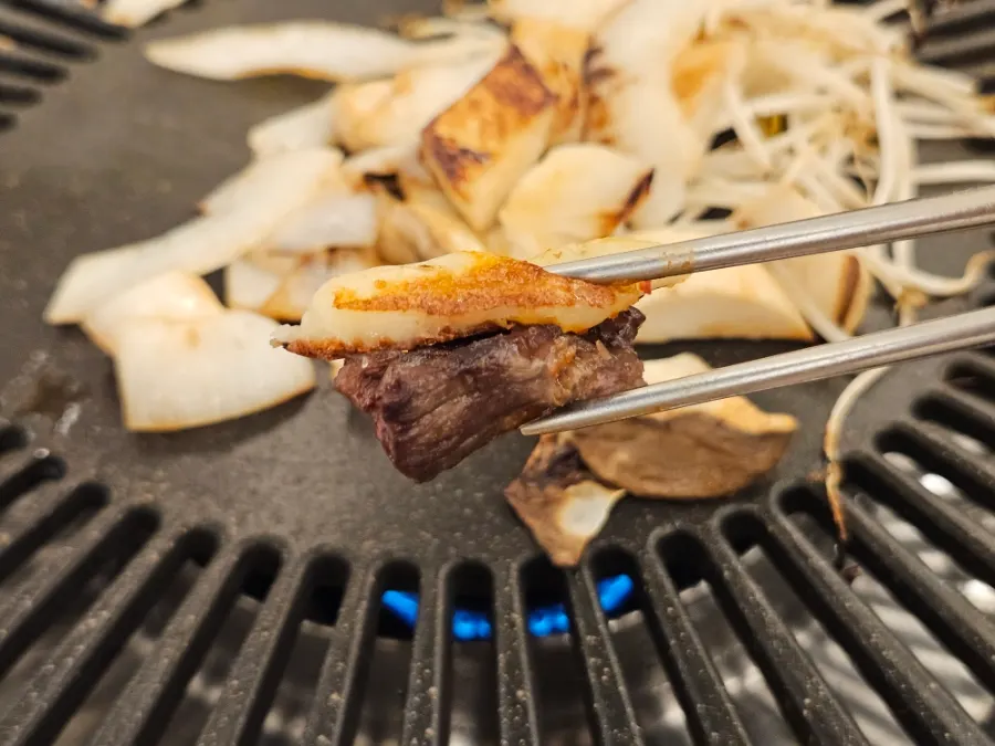 A bite of meat picked up together with cheese