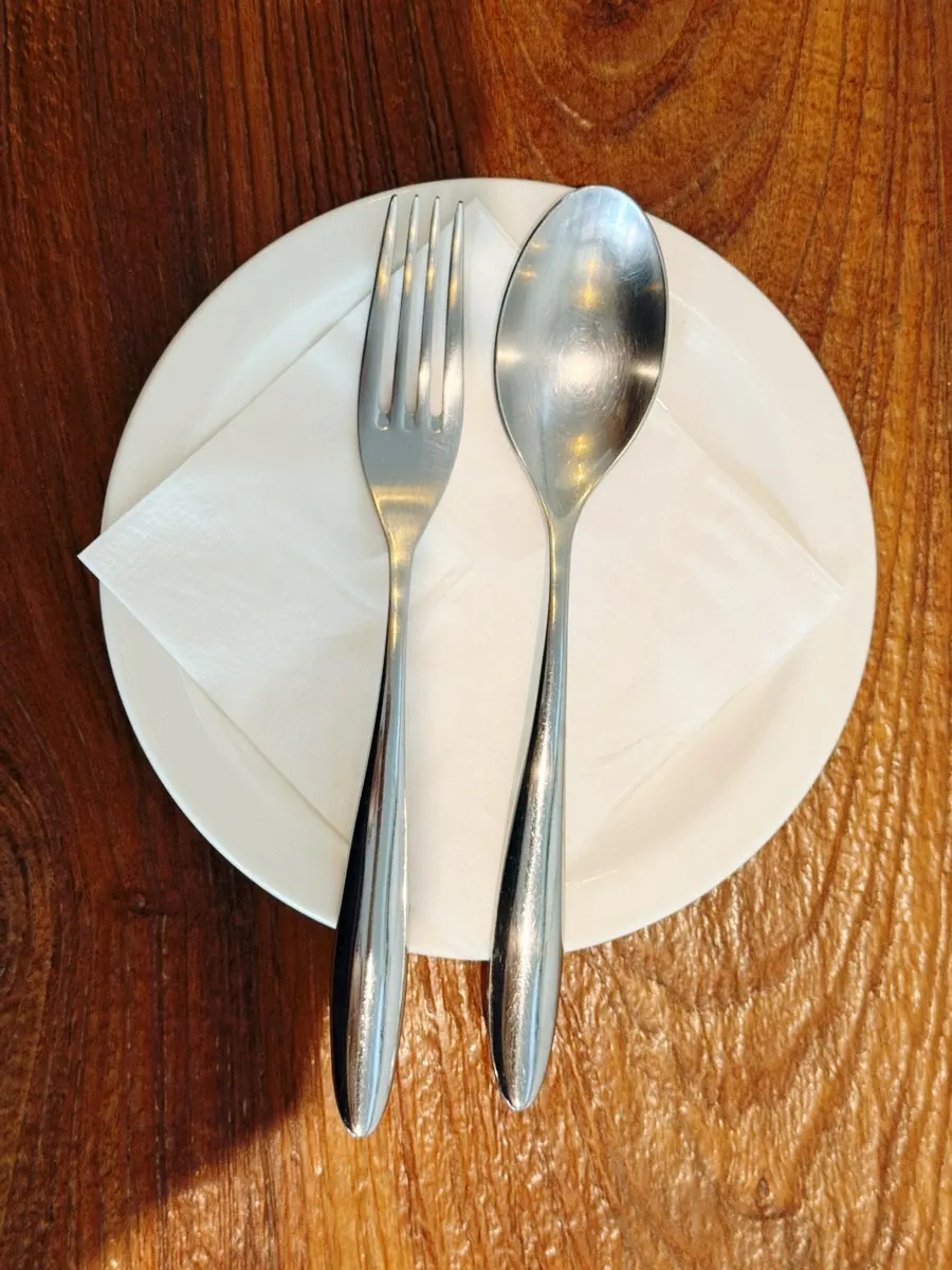 Water carafe and cutlery on a wooden table