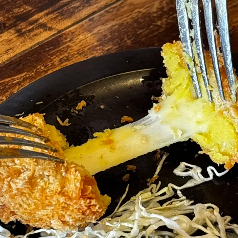 A cross-section of the sweet potato cheese croquette with cheese pull