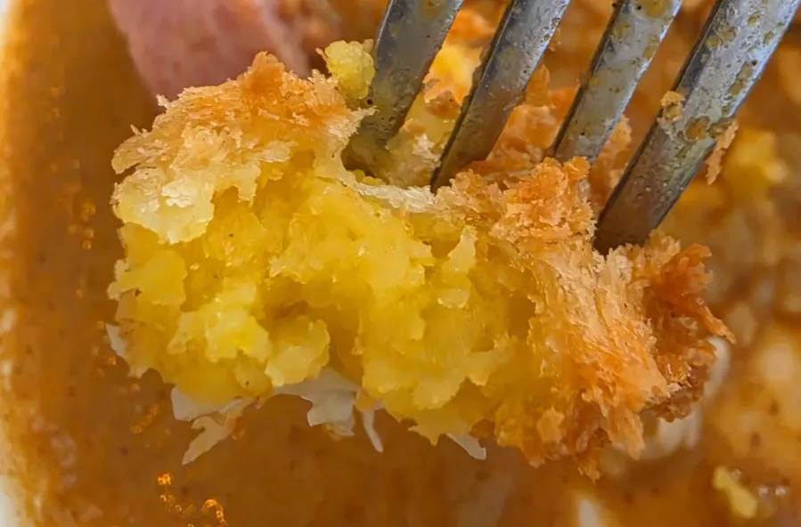 Cross-section of a sweet potato cheese croquette on salad