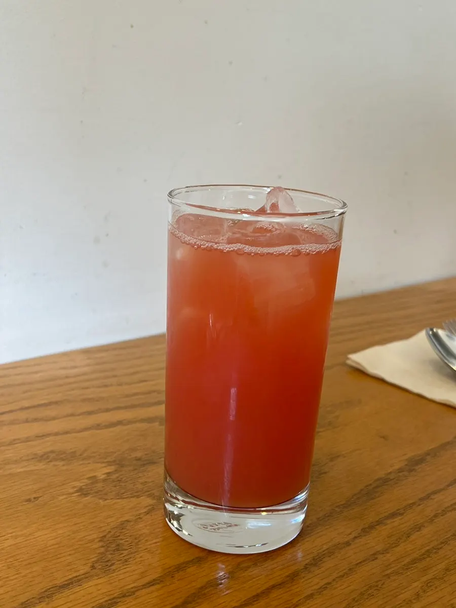 A glass of grapefruit juice served first