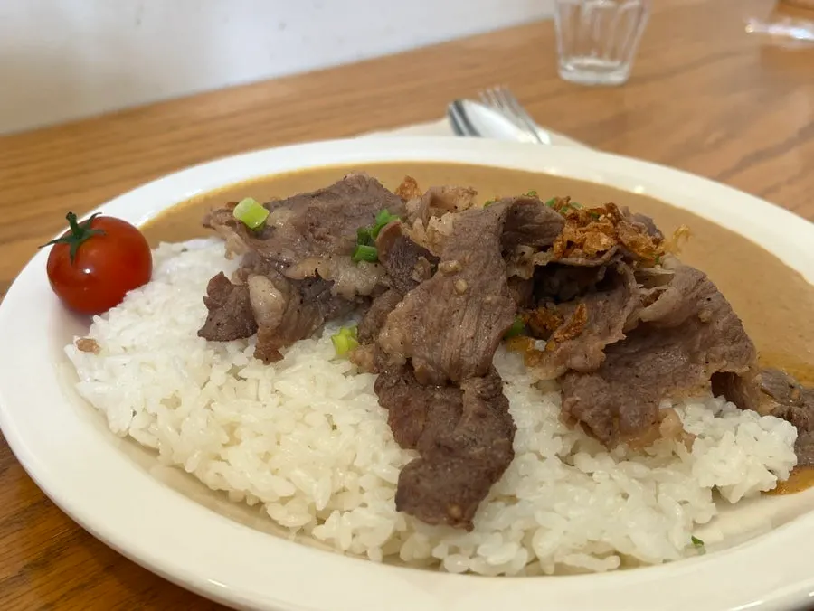 A spoonful of cream curry mixed with rice