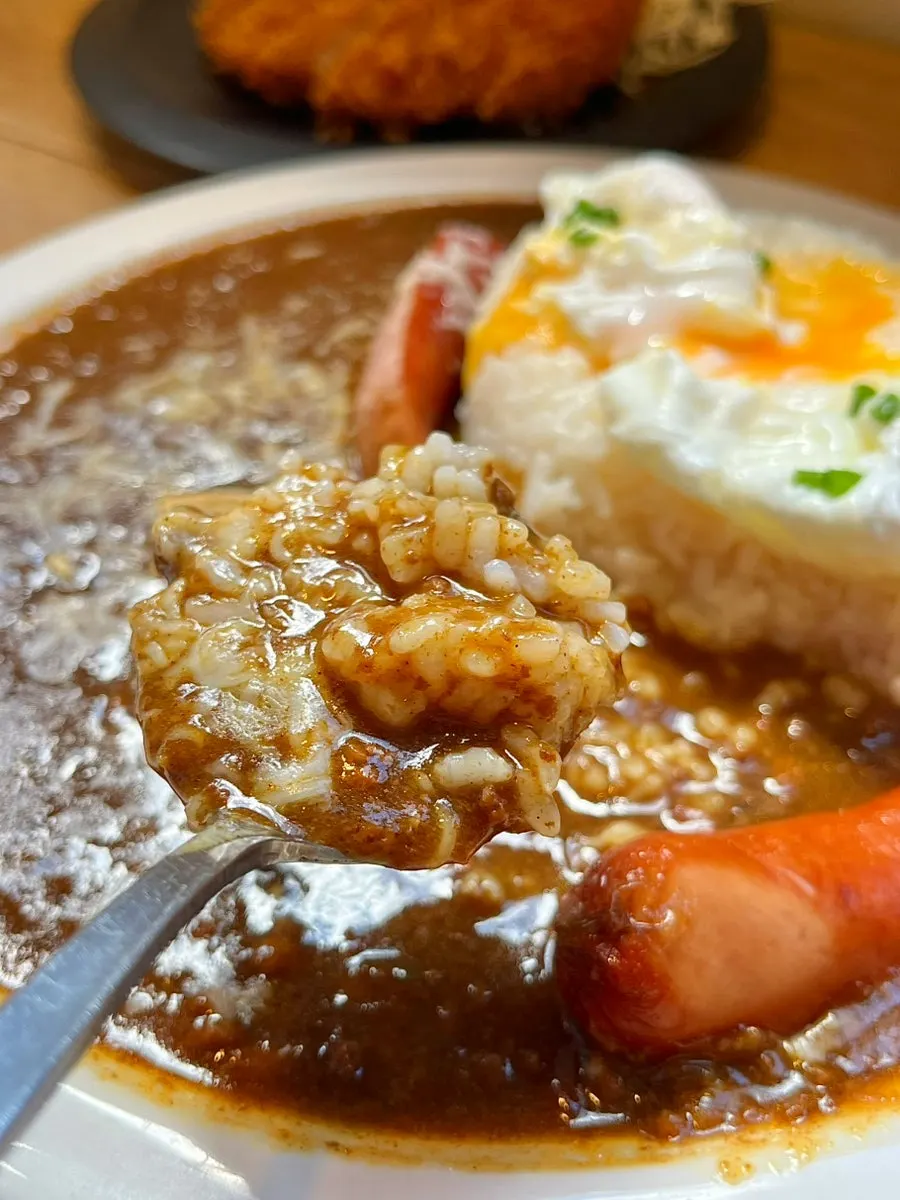 Curry topped with a soft-boiled egg and cheese