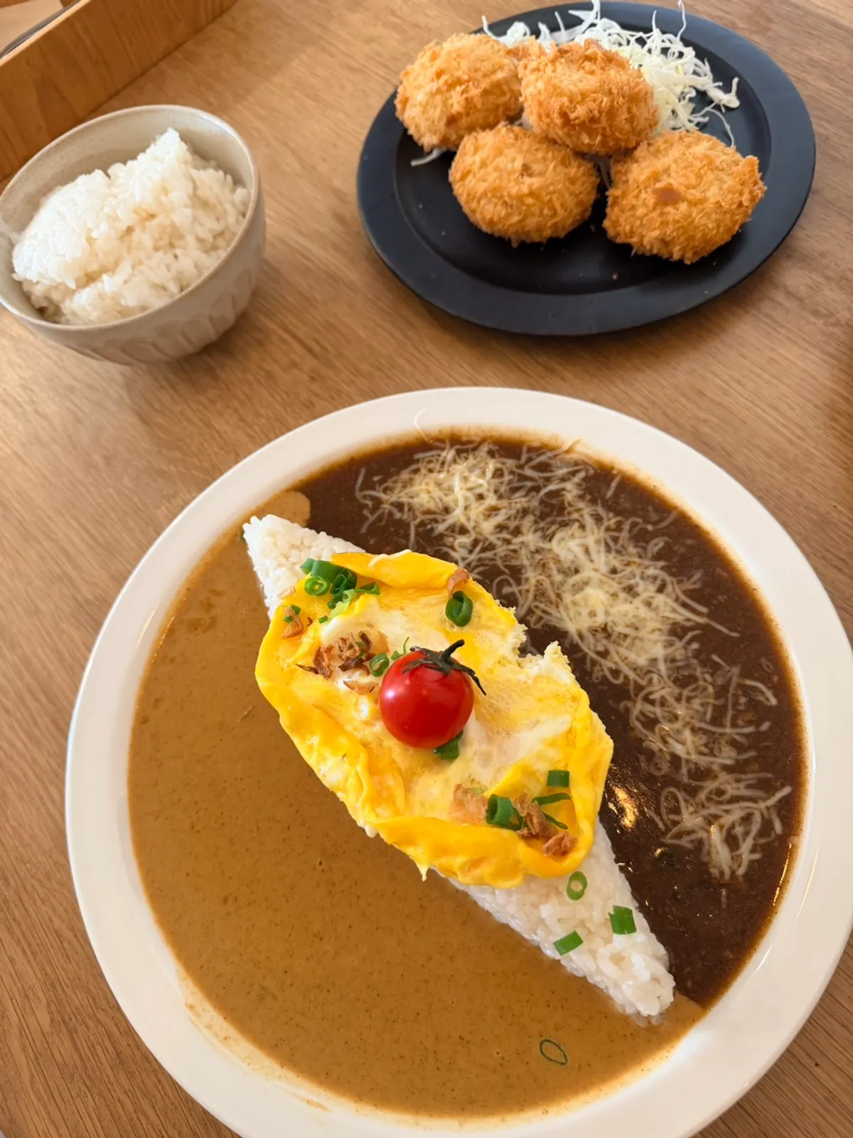 A bowl of half-and-half curry with an added omelet