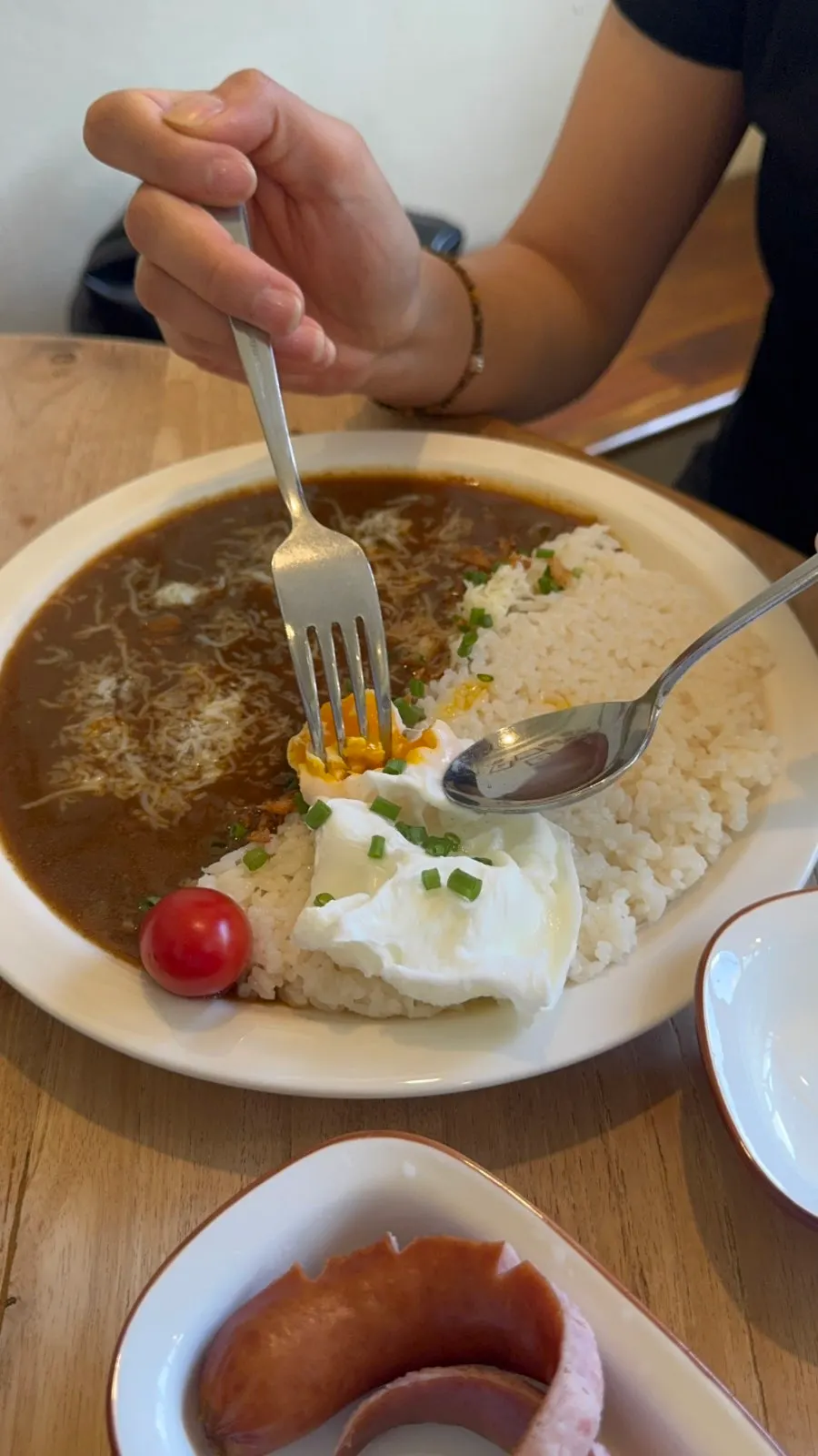 Curry with poached egg and sausage served separately