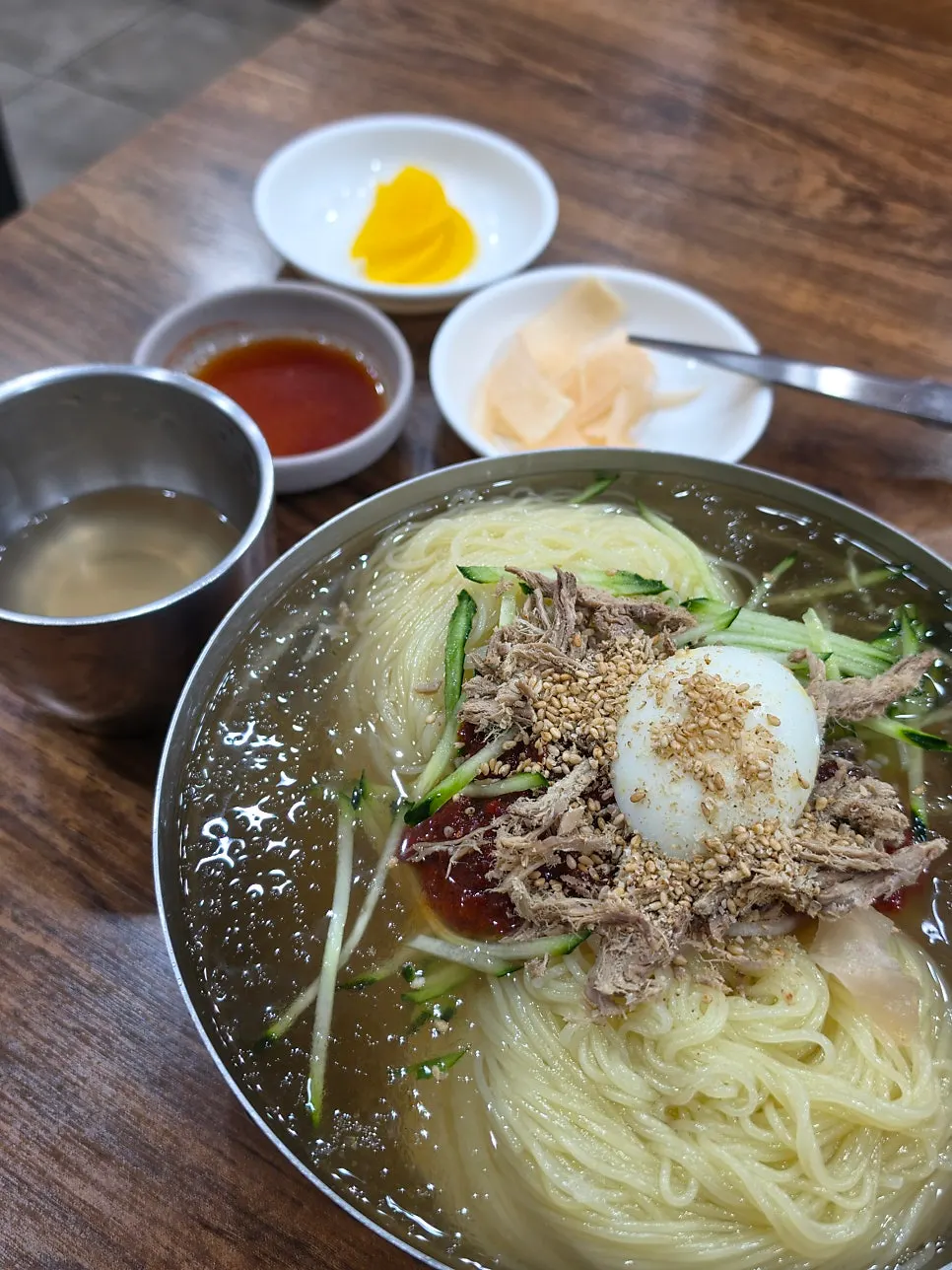 Seomyeon Milmyeon's mul-milmyeon topped with seasoning and garnish