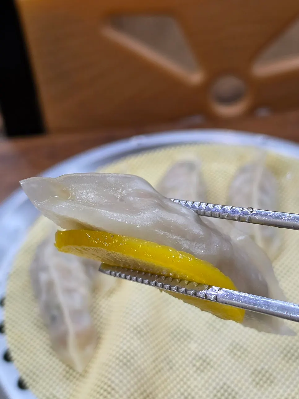 A dumpling dipped in soy sauce, cross-section shown