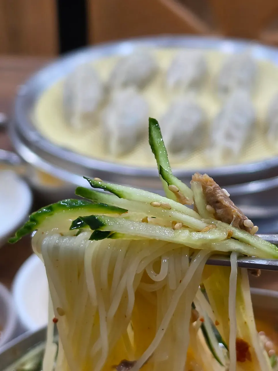 A solo meal spread of mul-milmyeon and dumplings together