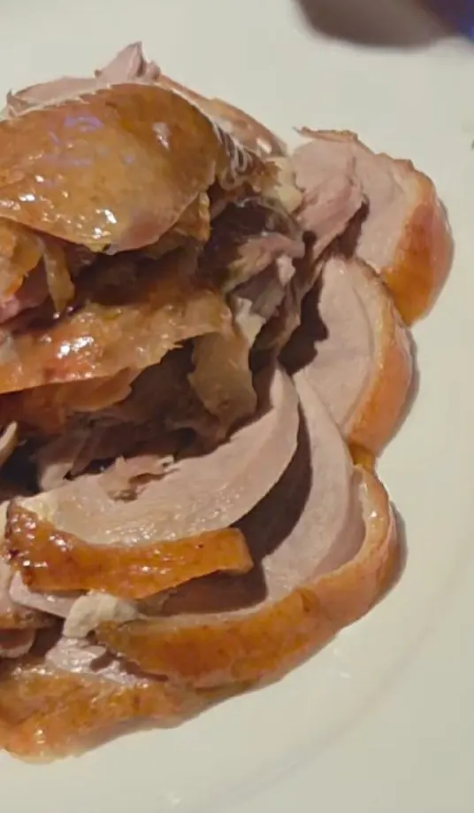 Peking duck wrapped in a thin wheat pancake
