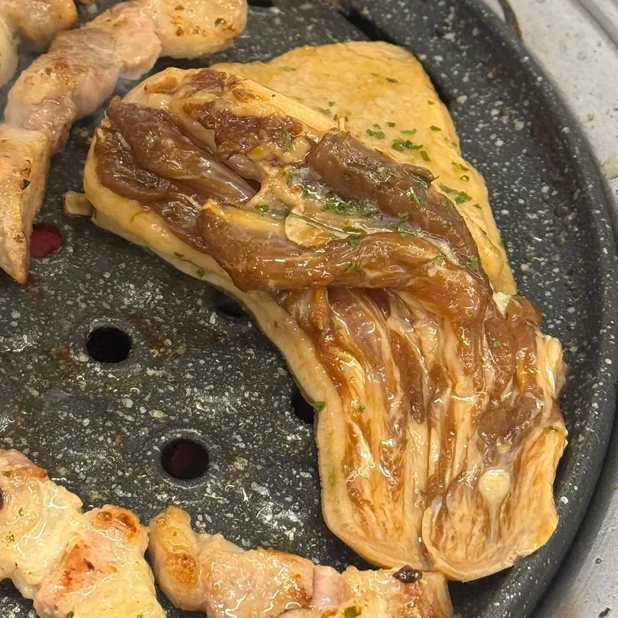 A piece of doraechang dipped in makjang
