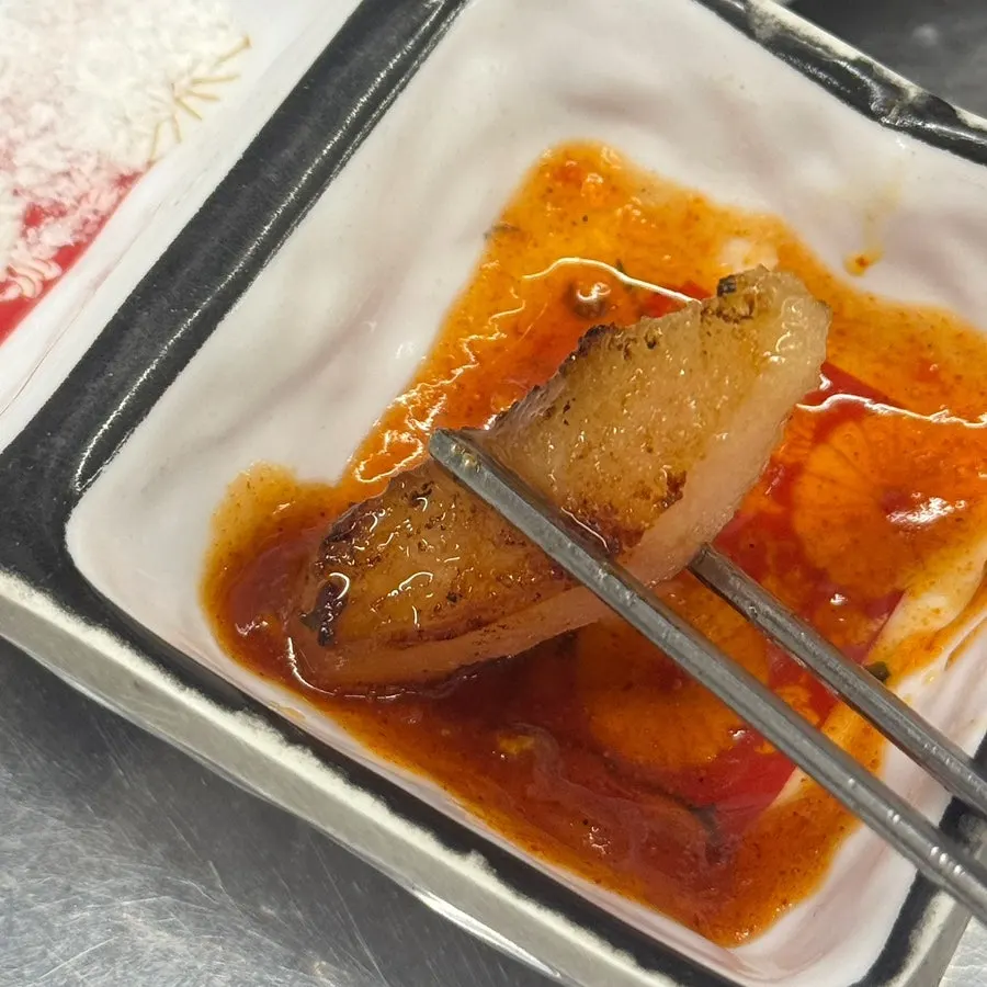 Chewy pig tail dipped in red sauce