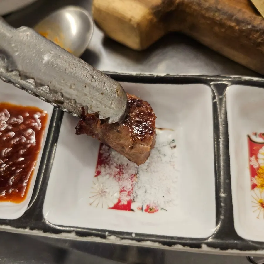A well-cooked piece of dwittongsal dipped in salt
