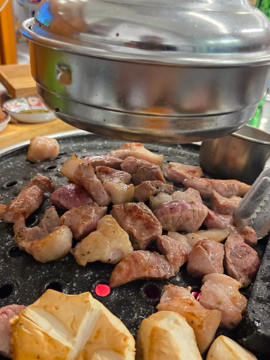 소주와 함께 놓인 구운 뒷고기
