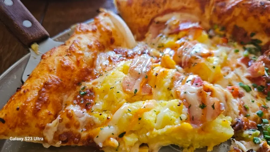 Egg potato pizza topped with mashed potato and egg