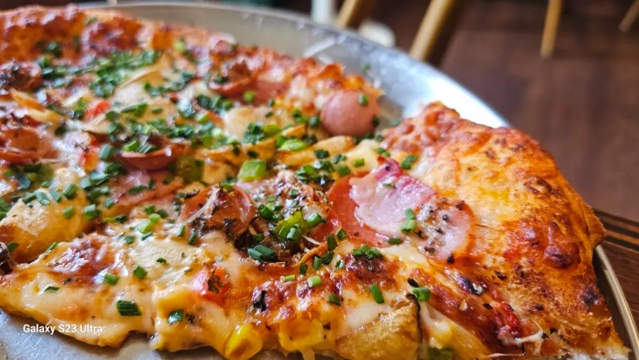Freewill pizza topped with sausage, bacon, and pepperoni