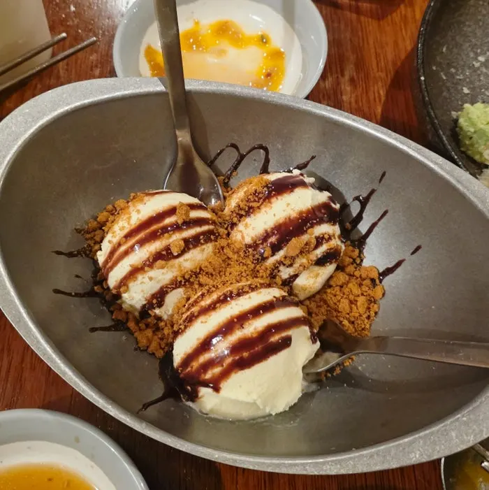Ice cream topped with chocolate sauce and cookie crumbs