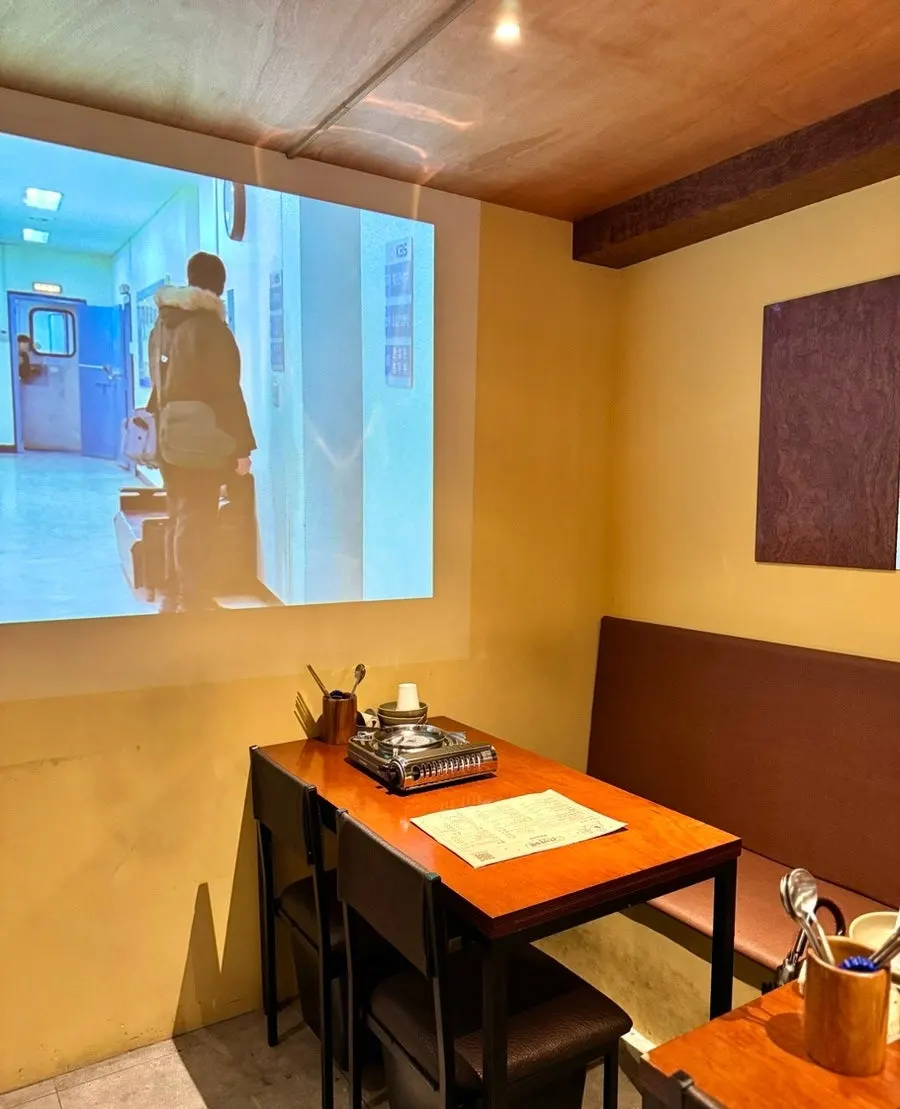 Hall seating at Ganbame with a large screen