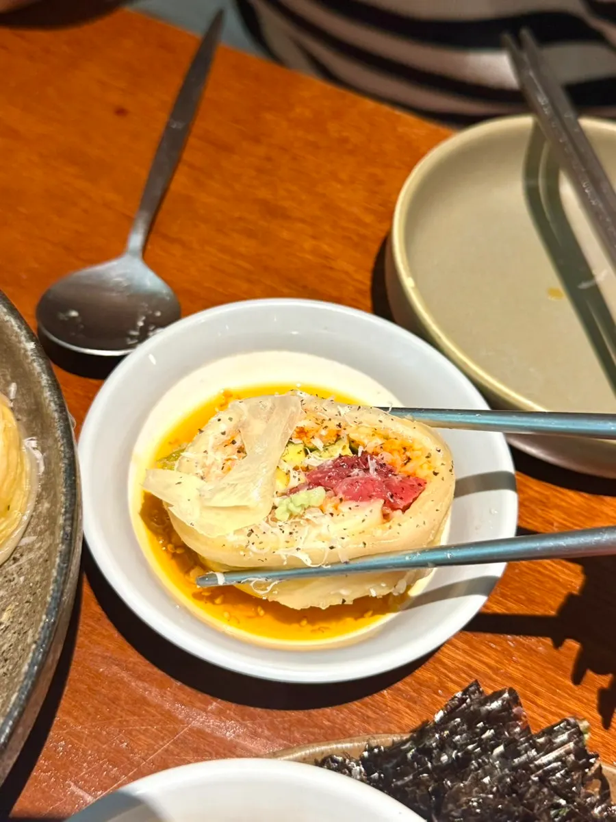 Close-up of raw beef kimchi roll topped with cheese