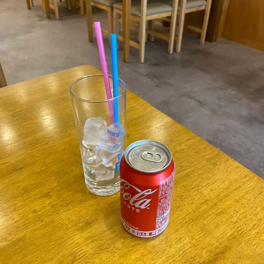 수저와 티슈가 놓인 테이블과 보리차