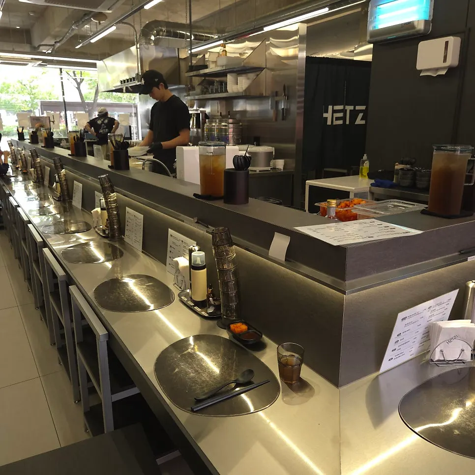 Long stainless bar table running along the kitchen