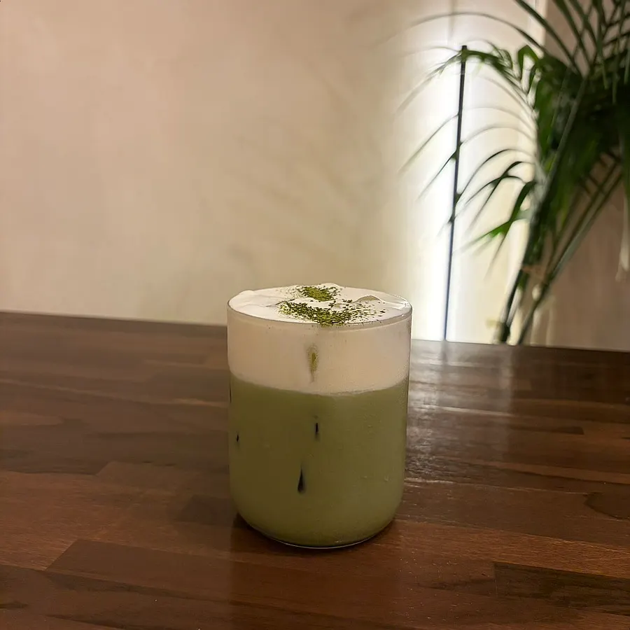 Matcha latte topped with a thick layer of cream