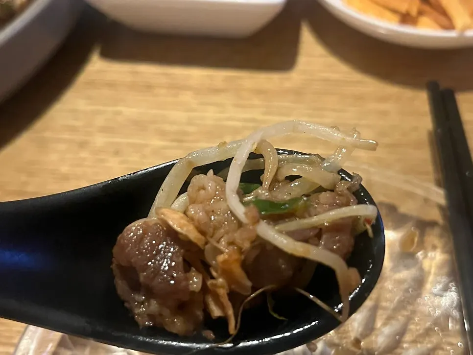 Close-up of spicy beef brisket and sprout stir-fry with chili