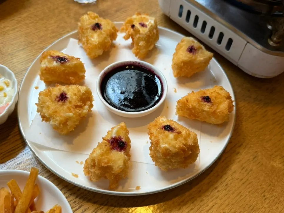 A plate of blueberry camembert cheese fritters