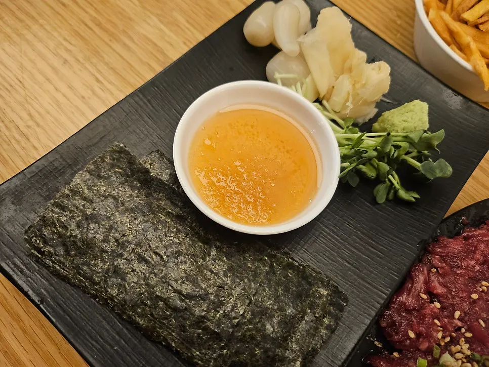 Beef sashimi on seaweed with radish sprouts