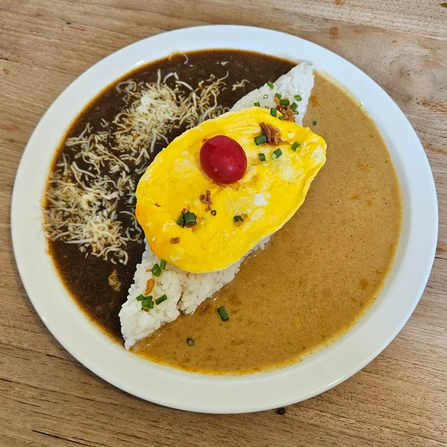 A plate of half-and-half curry topped with added scramble