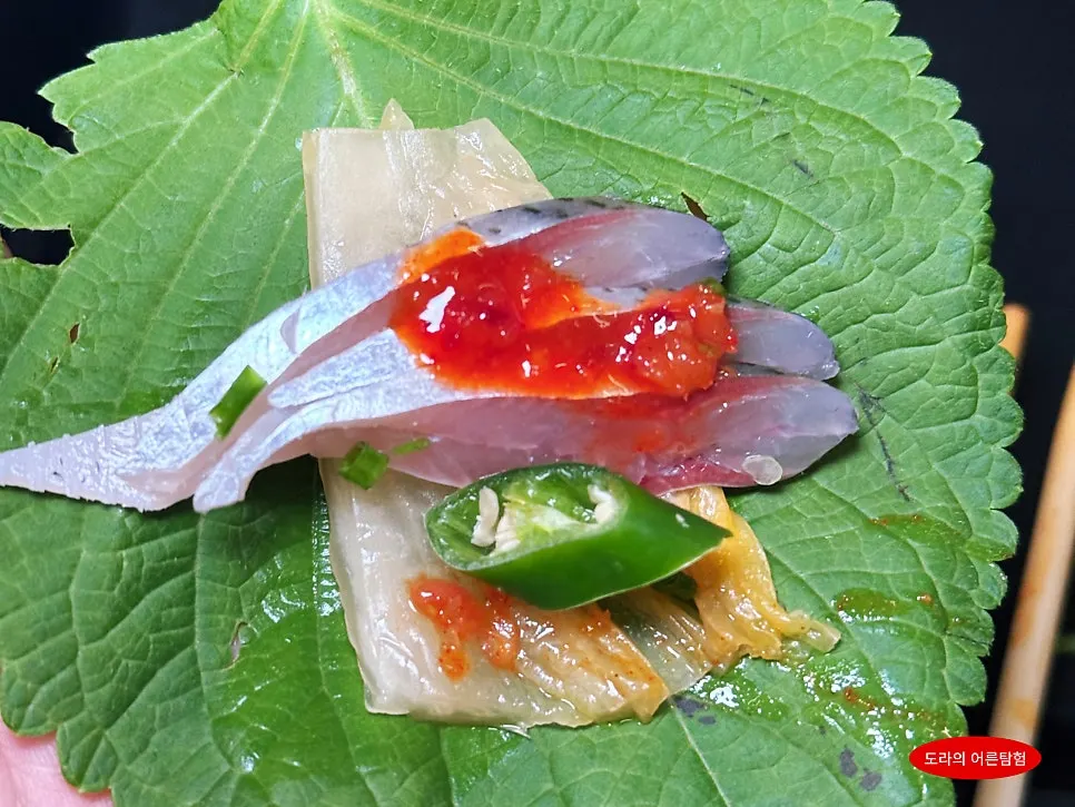 Gizzard shad sashimi wrapped in perilla leaf with garlic and chili