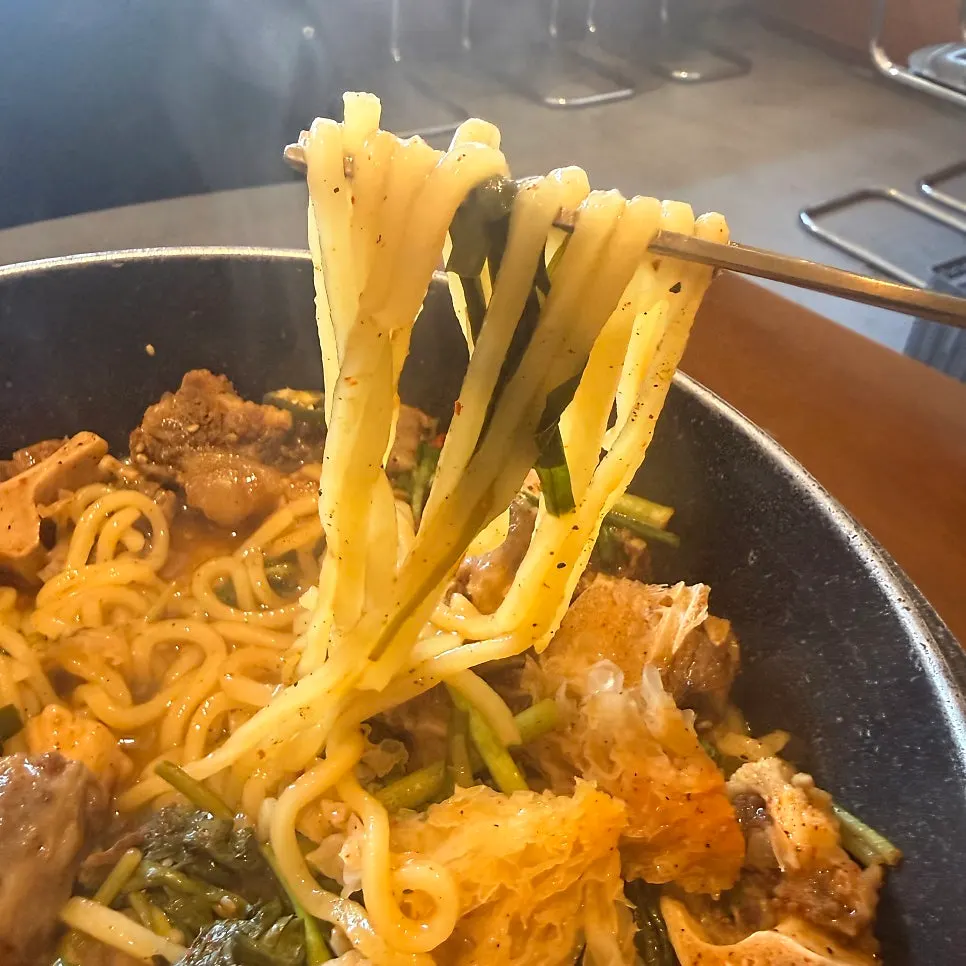 A chewy piece of ox tail meat picked up with chopsticks