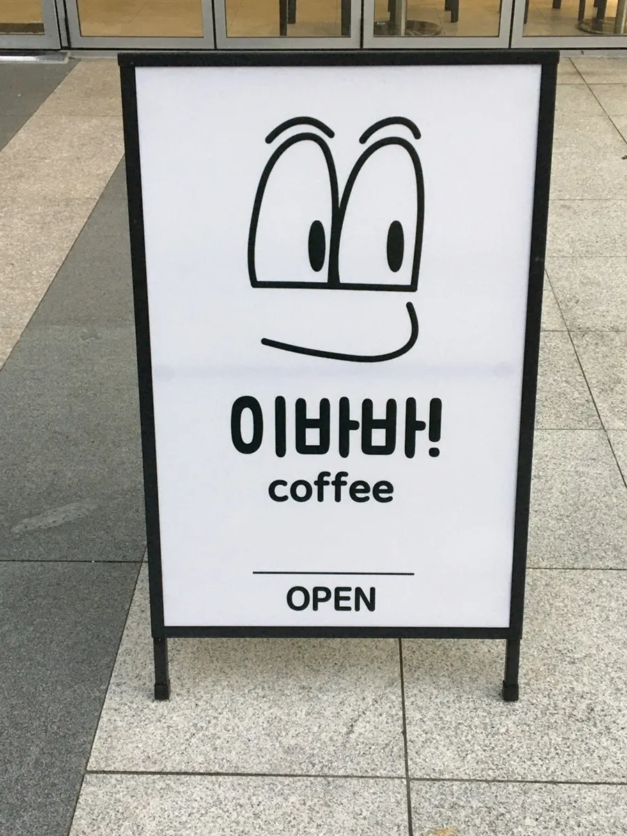Eye-shaped standing sign at the Ibaba Coffee entrance