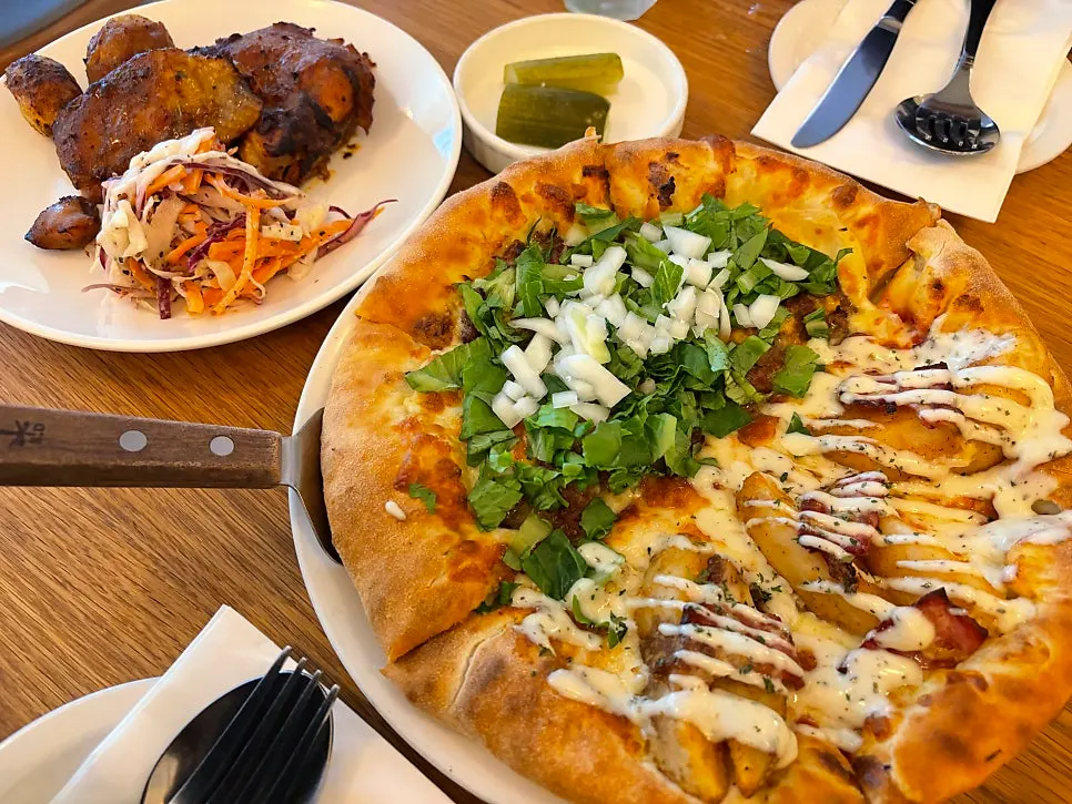 Half-and-half pizza and chicken steak set on the table