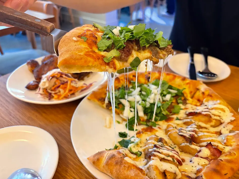 A slice of pizza with long stretchy cheese