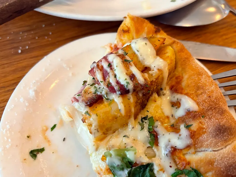 Potato pizza topped with potato wedges and bacon