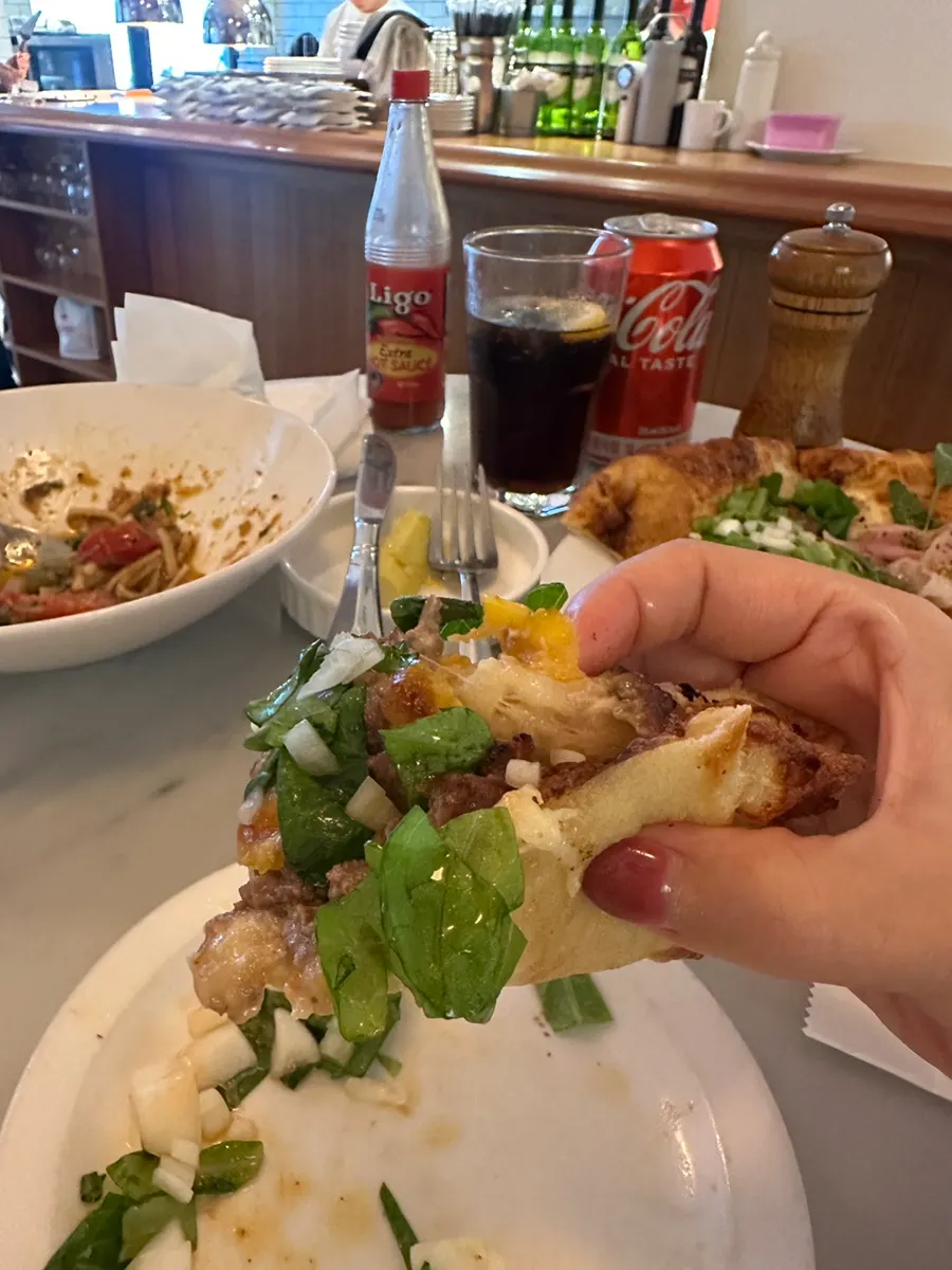 Cheese stretching from a slice of beef pizza