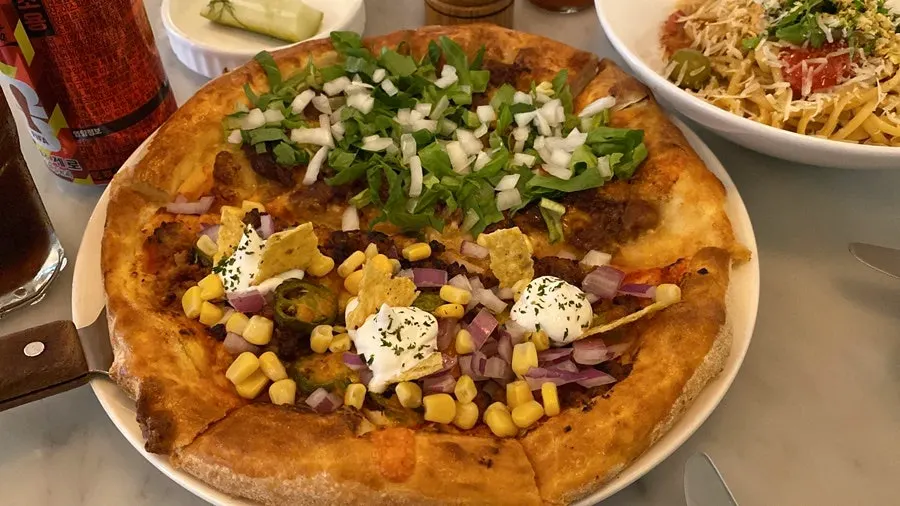 The half-and-half pizza split between taco and beef cheeseburger