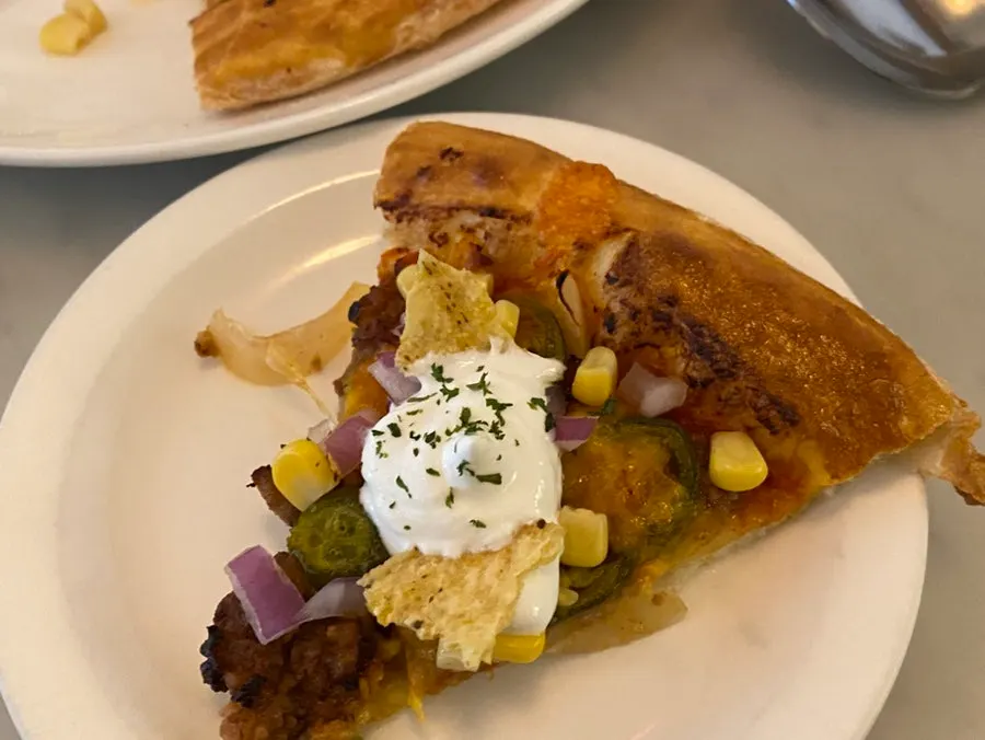 Picking up a slice of the taco pizza